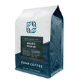 A 12 oz bag of Zuna Coffee Brazil Veloso medium roast coffee, featuring a white and dark teal packaging design with a dark green label.